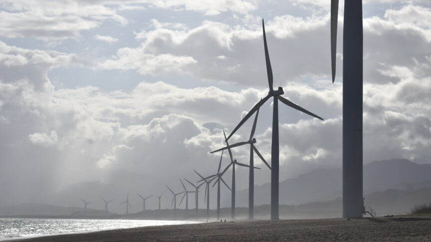 Een foto van een landschap met daarin een rij windmolens