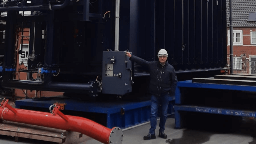 Foto van een medewerker die aanwezig is bij het transport van trafo units
